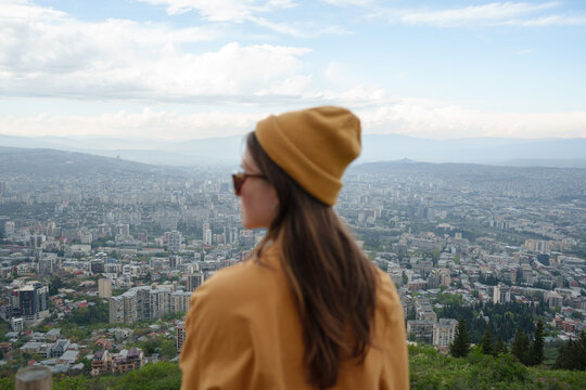 Young woman in the park looking over the city