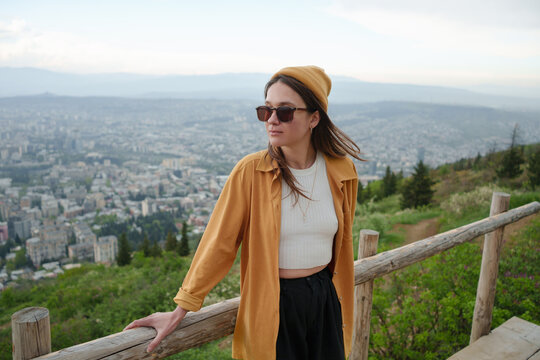 Young woman in the park looking over the city