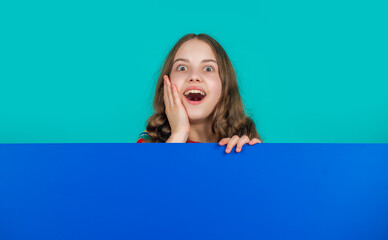 amazed child with blank blue paper with copy space for advertisement