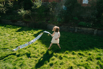Girl playing with silver tape  on the green grass