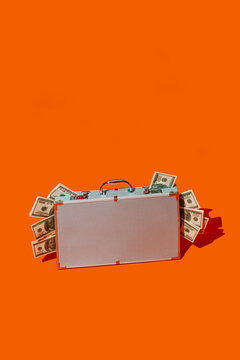 fake dollars peeking out of a metal briefcase