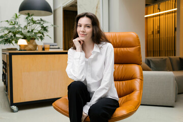 Portrait of a young attractive woman in a designer chair