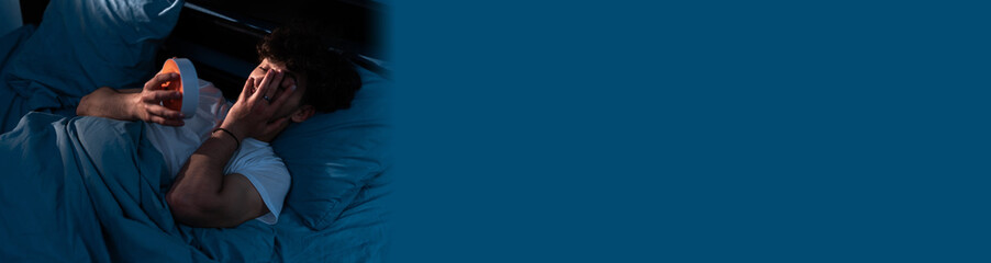 Frustrated young man in bed suffering insomnia. Awake in the middle of the night. Frustrated person...