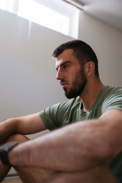 Man sitting with intense focus in living room.