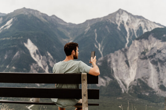 man using phone at mountain
