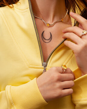 A bodypart of young woman in a fashionable yellow sweatshirt.