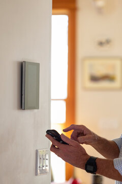 Smart Home technology Panel in Home with man typing on smarphone app
