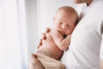 Newborn baby sleeping on his father's chest. 