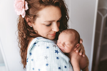 Beautiful mother holding and burping her newborn baby.
