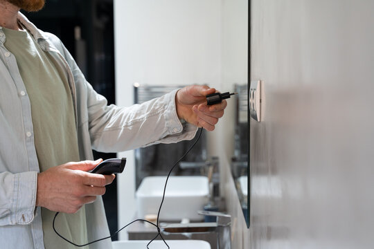 Man charging electric razor machine 