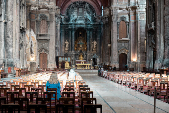 unrecognizable woman sitting praying in cathedral