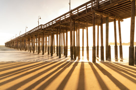 Fototapeta Sunset through wood pier Ventura California