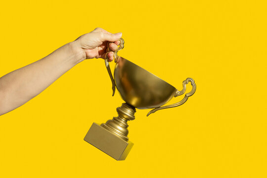 Winner holding golden cup. Success and achievement, victory concept.