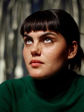 Brunette woman with hopeful, devote expression looking up
