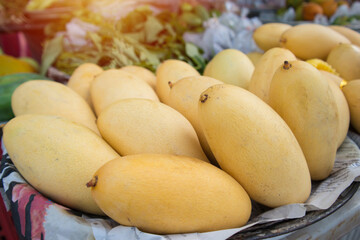 mango fruit in basket on wooden table. 