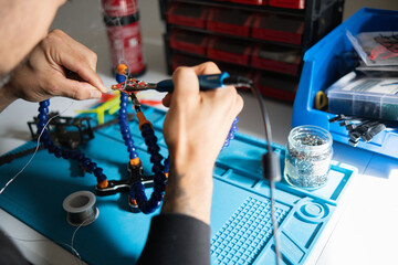 man fixing electronic component of a drone