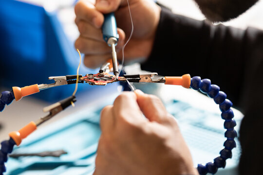 man fixing electronic component of a drone
