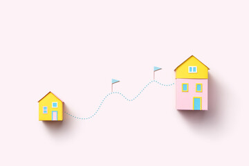 Papercraft houses connected by dotted line and flags.
