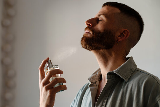 Man applying perfume to his neck