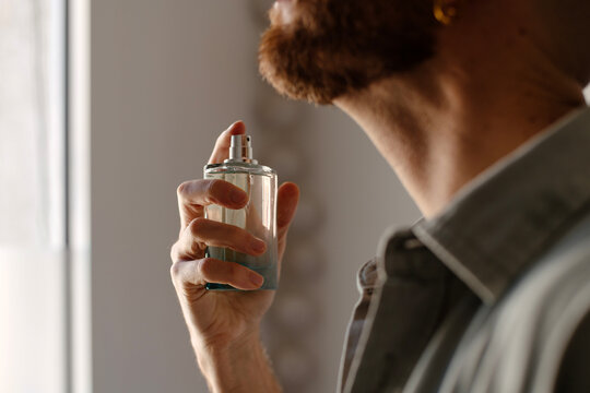 Man applying perfume to his neck