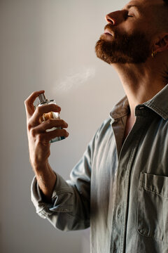 Man applying perfume to his neck
