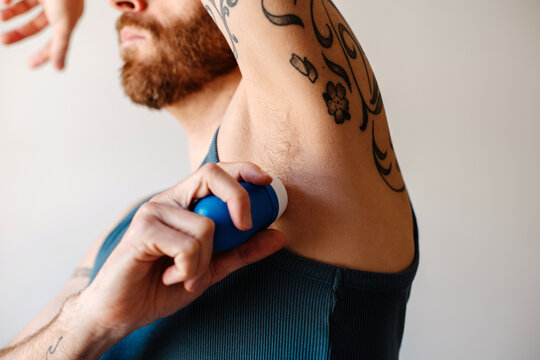 Man applying deodorant on his armpit