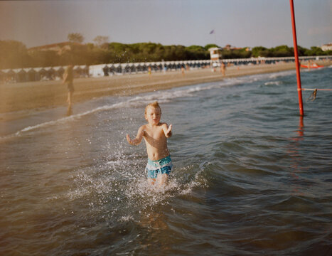 A funny blond kid at a beach