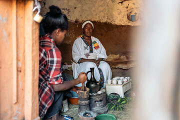 Ethiopian women roasting coffee in traditional home.