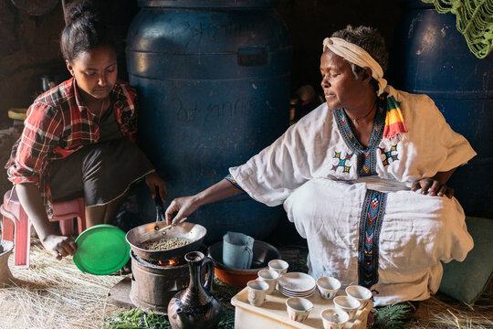 Ethiopian women roasting coffee at traditional home.