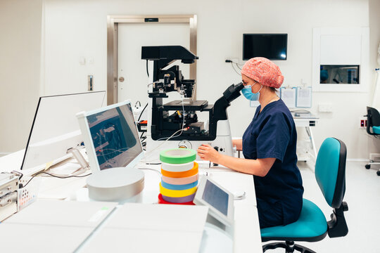 Female laboratory worker using microscope in lab