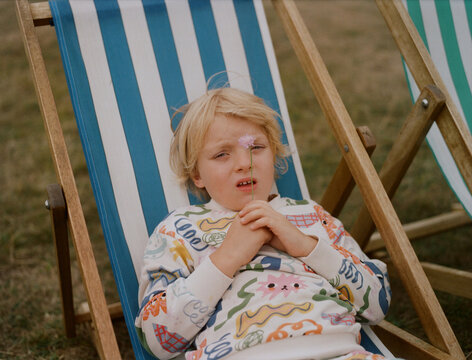 a blond kid in a sun lounger
