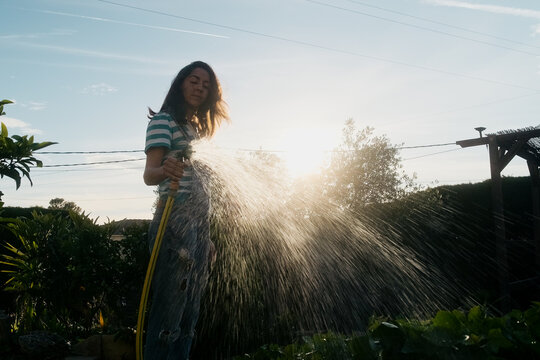 Woman watering the garden with a hose