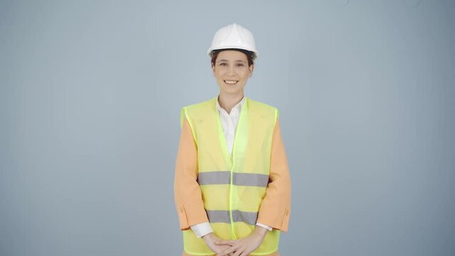 The engineer wearing a hard hat and smiling.