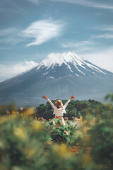 Happy tourist traveler woman enjoying with open arms on lake kawaguchiko with mount fuji in japan,...
