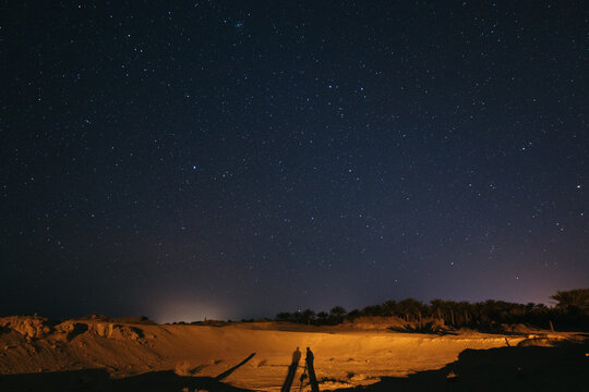 Two photographers taking night photos under the stars in the desert
