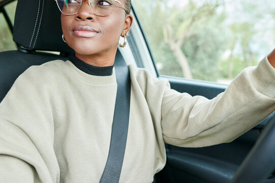 Smiling young woman driving her car