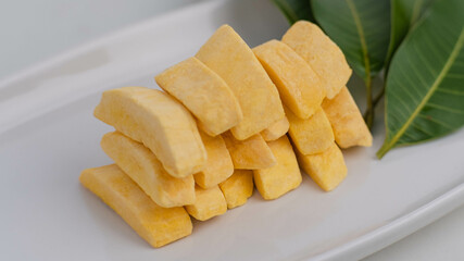 Healthy freeze dried fruits. Freeze-dried mango in plate on table, close-up.
