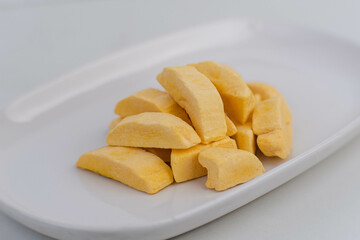 Healthy freeze dried fruits. Freeze-dried mango in plate on table, close-up.