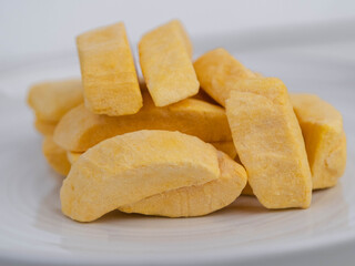 Healthy freeze dried fruits. Freeze-dried mango in plate on table, close-up.