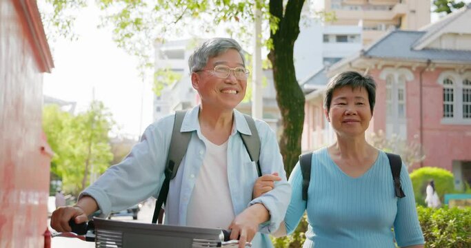 asian elderly couple walk together