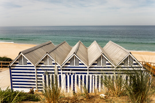 landscape of a beach with blue houses with white stripes