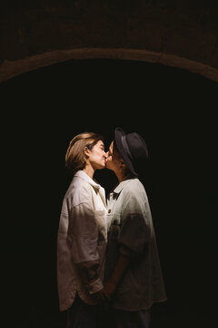 Homosexual women kissing in darkness