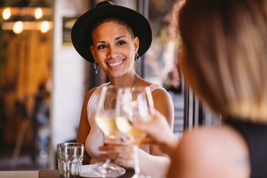 Happy Lesbian Couple Toasting With White Wine In A Restaurant