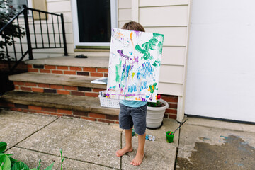 Boy shows off canvas painting
