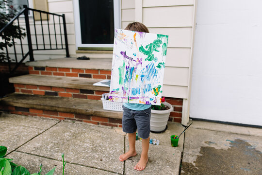 Boy shows off canvas painting