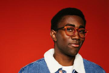 Cheerful man smiling against red wall
