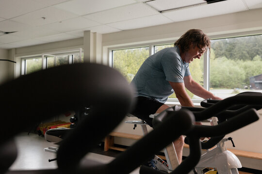 Fit mature man in exercise bike working hard.
