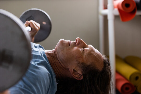 Man doing bench press exercise in rec center gym.