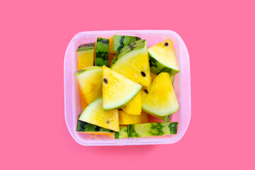 Yellow watermelon slices on pink background.