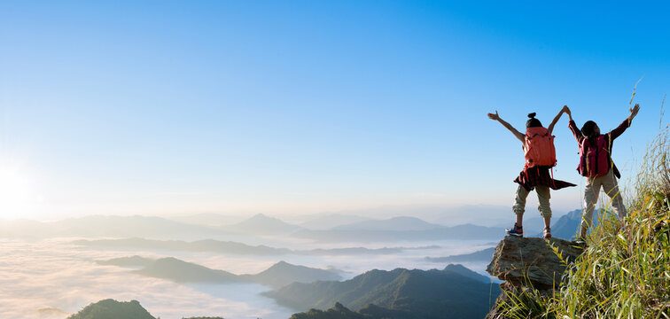 Group of happy hiker raised up arms on the mountain